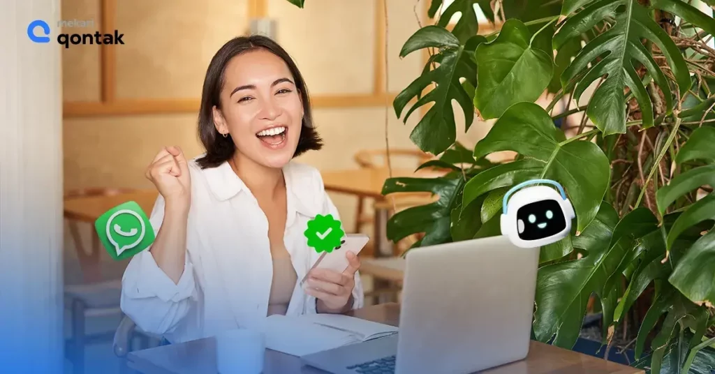 Benefits of using WhatsApp Business API Sebuah wanita muda sedang bekerja di depan laptop sambil tersenyum, dikelilingi oleh tanaman indoor, dengan ikon aplikasi pesan yang muncul di sekelilingnya.