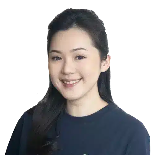 Seorang wanita mengenakan kaos biru gelap berdiri dengan postur tegak. Latar belakang hitam memberikan fokus pada figur dan suasana tenang.