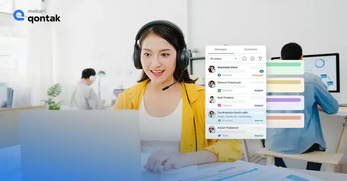 Seorang wanita mengenakan headphone dan baju kuning sedang berkomunikasi melalui komputer, dikelilingi oleh suasana kantor modern dengan rekan kerja di latar belakang.