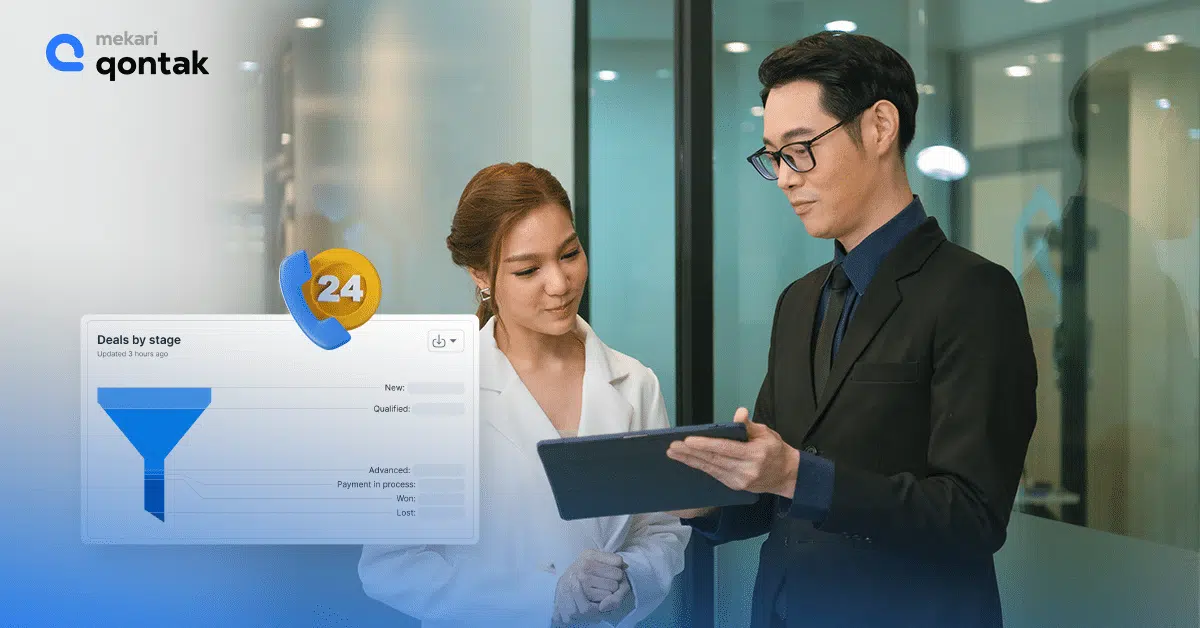 Seorang pria mengenakan jas berdiskusi dengan wanita berpakaian formal di ruang kantor modern, sambil memperlihatkan data terkait transaksi di tablet.