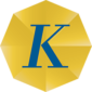 Huruf "K" yang besar berwarna biru terletak di atas latar belakang kuning, menciptakan kontras mencolok yang menonjolkan identitas merek.