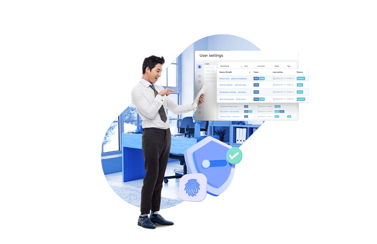Seorang profesional mengenakan jas dan dasi, menunjuk ke layar pengaturan pengguna di ruang kerja modern, menggambarkan pengelolaan data anggota tim.
